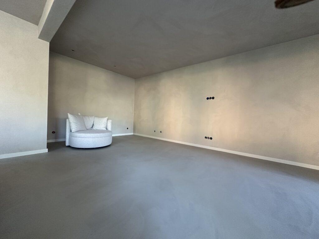 Woonkamer met American Clay leemwand en gietvloer, uitgevoerd door InterPleister Almere