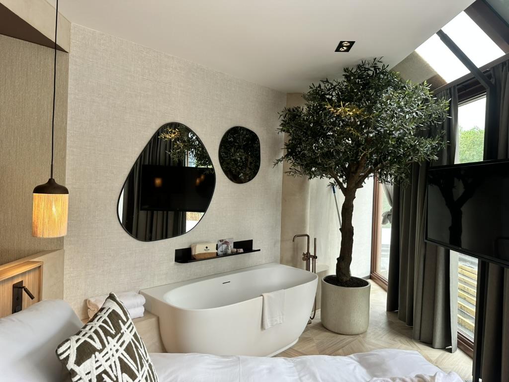 Badkamer met vrijstaand bad en wanden in microcement, hotelproject Valkenburg