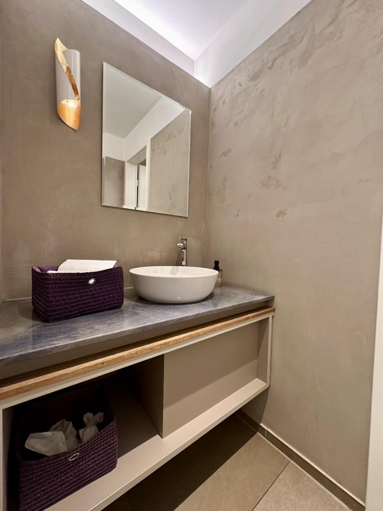 Toilet met wanden en wastafelblad in beton ciré