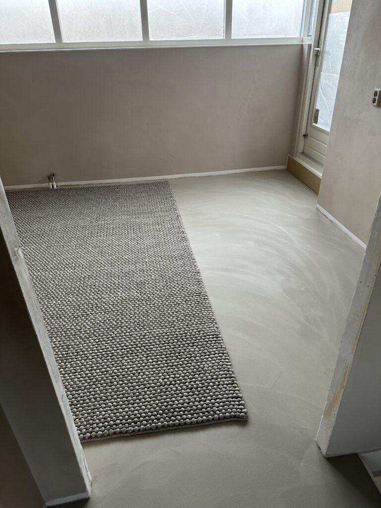 Gietvloer met vloerkleed in woonkamer