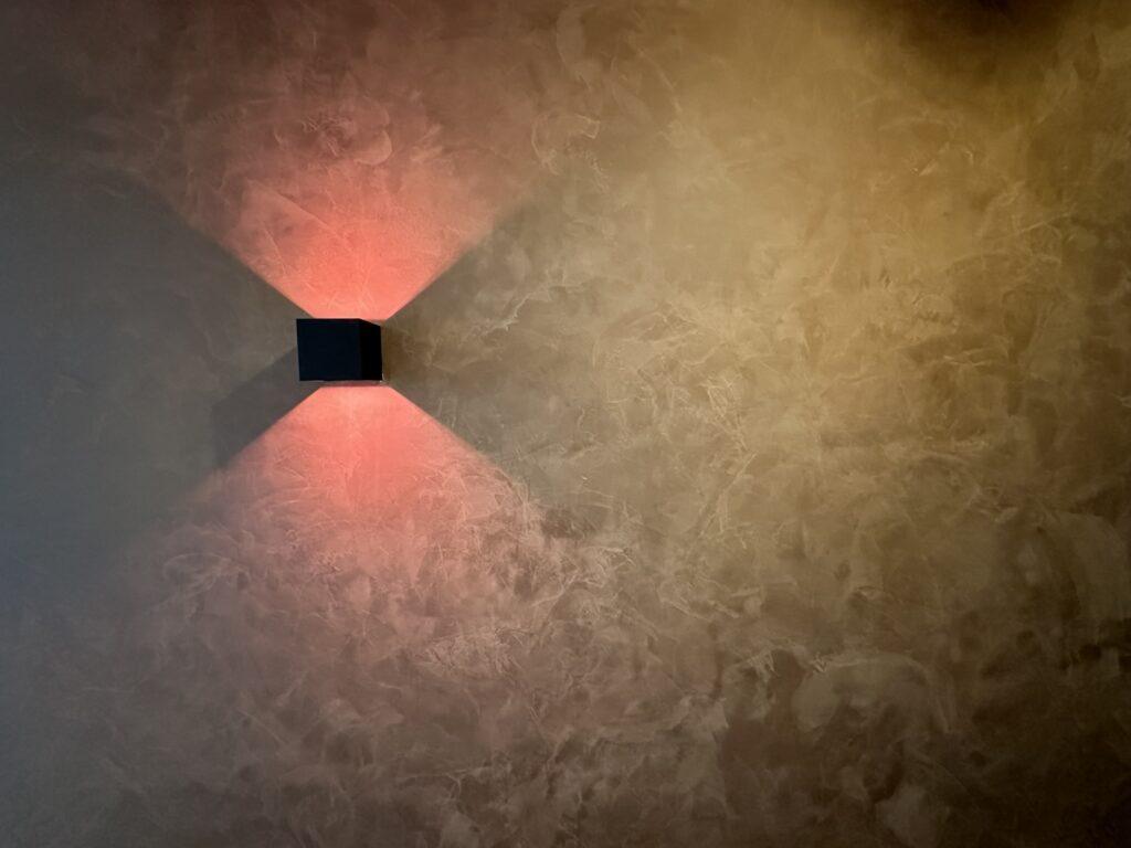Fluweelstuc wand met wandlamp in gang