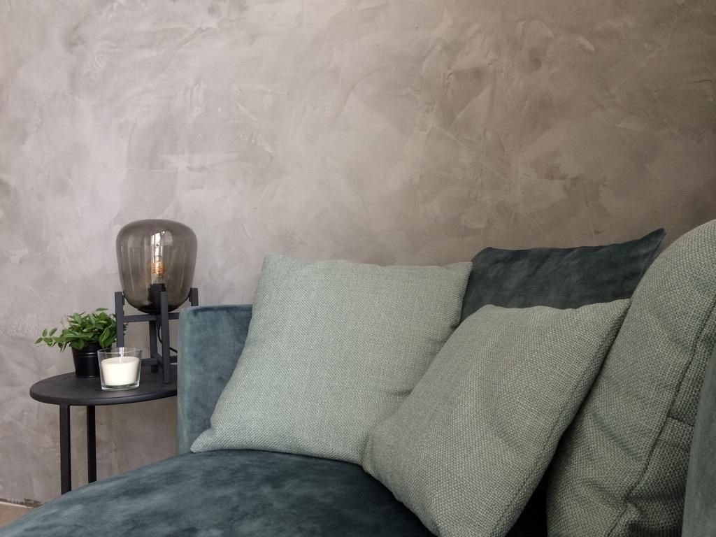 Woonkamer met wand in Novacolor stucwerk, greige tint, uitgevoerd door InterPleister