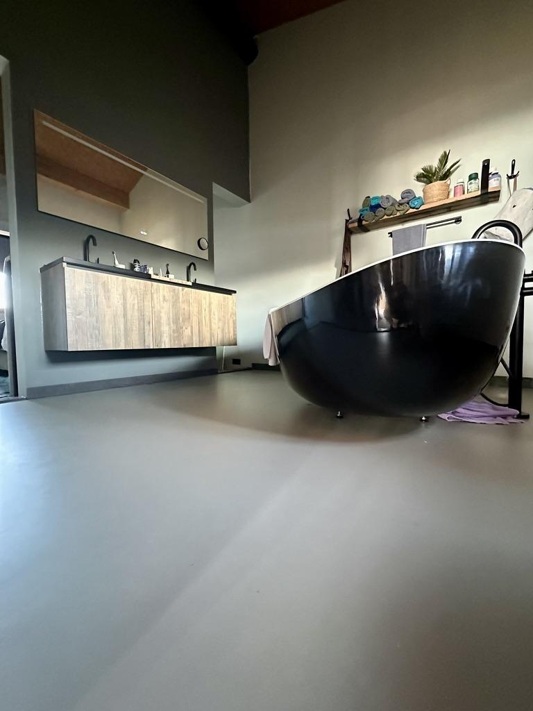 Badkamer met zwart vrijstaand bad op PU gietvloer, Almere