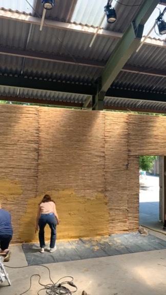 Leem aanbrengen op wand met steiger