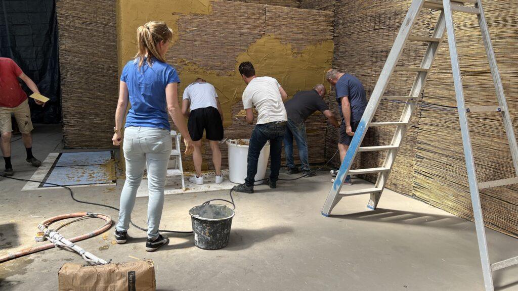 Team van InterPleister brengt leem aan op rietwand