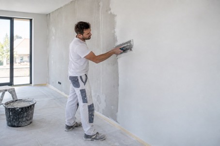 Stukadoor pleistert een wand glad